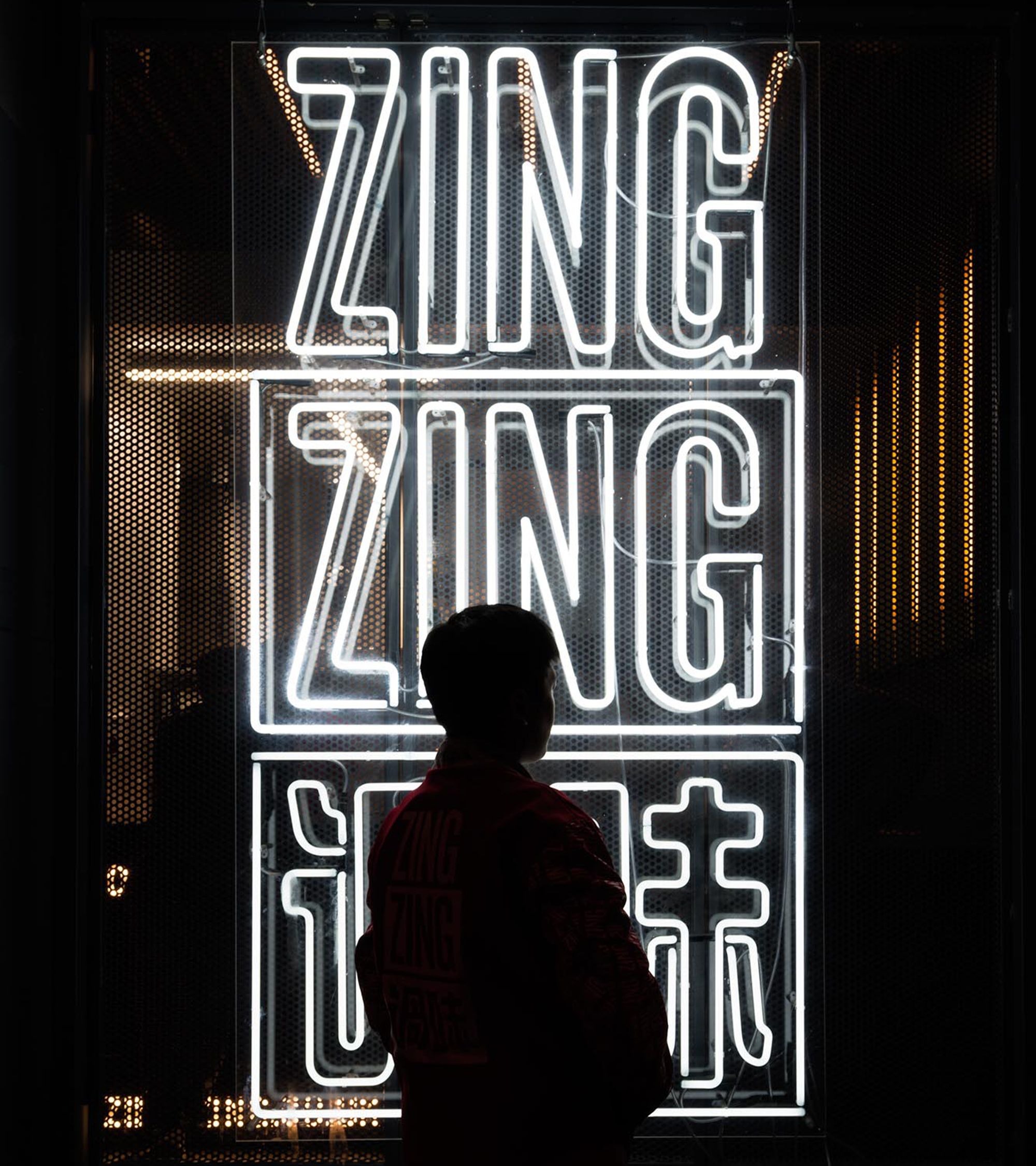 Woman in a suit, holding a flower, bathed in warm light